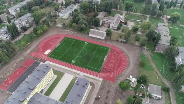 Футбольне поле з ідеальною зеленою травою. Футбольне поле з біговою доріжкою навколо — стокове відео