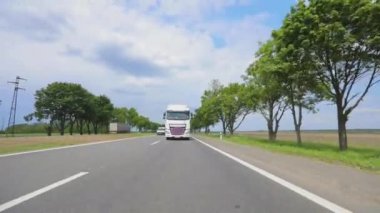 Otoyol boyunca giden beyaz bir kamyon. Tankerli bir kamyon güneşli havada otoyola çıkıyor. Bir kamyon konvoyu otoban boyunca gidiyor.