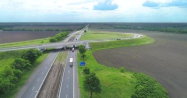 Kamyonlar yol boyunca gidiyor. Otoyolda giden tank kamyonları. Otoyol manzarası boyunca giden kamyonlar. Banliyö yolunda kamyonlar sürüyor.