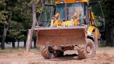 İnşaat alanında sarı traktör. İnşaat alanında çalışma süreci. Profesyonel inşaat ekipmanları.