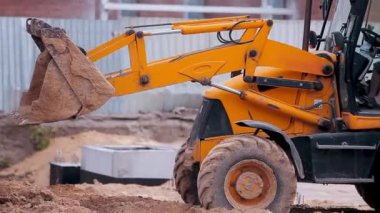 İnşaat alanında sarı traktör. Profesyonel inşaat malzemeleri. İnşaat alanında çalışma süreci