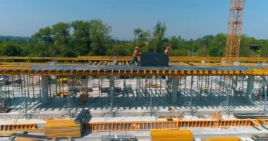 Modern bir futbol stadyumunun yapım süreci. İnşaatçılar yeni bir stadyumun şantiyesinde resmi işler yapıyorlar. Güçlendirilmiş beton yapının havadan görüntüsü