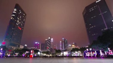 İnsanlar Guangzhou 'nun geniş bir alanında yürürler. Geceleri Guangzhou 'da. Guangzhou 'daki parlak yüksek binalar.