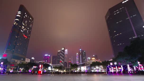 Οι άνθρωποι περπατούν σε μια μεγάλη περιοχή της Guangzhou. Guangzhou τη νύχτα. Φωτεινά ψηλά κτίρια στο Guangzhou — Αρχείο Βίντεο