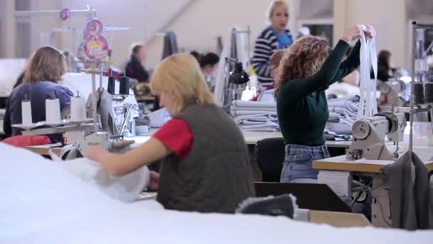 Werkproces in de werkplaats van een kledingfabriek. Werken in een naaiatelier. Naaisters werken in een textielfabriek — Stockvideo