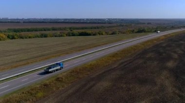 Nakliye aracı. Kamyon modern bir yolda gidiyor. Kamyon güneşli havada otoyol boyunca sürer. Pistte kamyon var