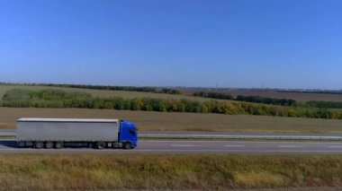 Kamyon güneşli havada otoyol boyunca sürer. Kamyon modern bir yolda gidiyor. Pistte kamyon var
