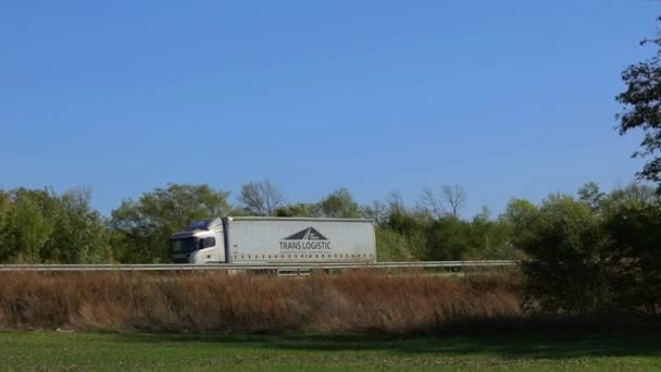 O camião está a conduzir na auto-estrada. O caminhão dirige na estrada em torno dos campos — Vídeo de Stock