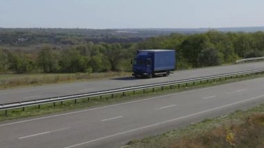 Nakliye aracı. Kamyon modern bir yolda gidiyor. Kamyon güneşli havada otoyol boyunca sürer. Pistte kamyon var