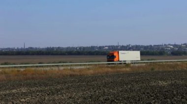 Kamyon güneşli havada otoyol boyunca sürer. Kamyon modern bir yolda gidiyor. Pistte kamyon var