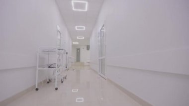 Kamera hastanenin boş koridoru boyunca döner. Modern bir hastanenin koridorları. Kliniğin boş, parlak koridoru. Modern bir kliniğin içinde.