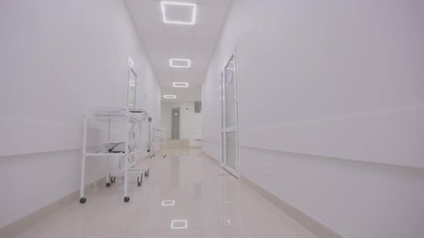 The camera pans along the empty hallway of the hospital. Corridors of a modern hospital. The empty, bright corridor of the clinic. Interior of a modern clinic — Stock Video