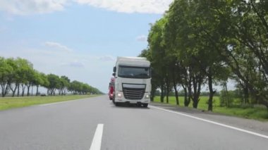Modern kamyonlar sıvı kargoyu tanklarla taşır. Kamyon otoyol boyunca gidiyor. Bir grup kamyon otoban boyunca gidiyor.