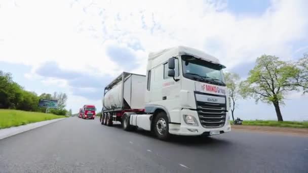 Un camion con una cisterna guida in autostrada con il tempo soleggiato. Un convoglio di camion guida lungo l'autostrada. Camion bianco guida lungo l'autostrada. — Video Stock
