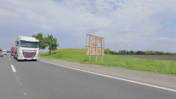 Weiße Lastwagen fahren die Autobahn entlang. Ein Lastwagen mit Tankwagen fährt bei sonnigem Wetter über die Autobahn. Ein Lastwagenkonvoi fährt über die Autobahn — Stockvideo