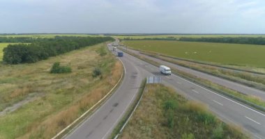 Araba manzaralı bir yol. Şehrin dışındaki otoyol, yolun kenarındaki tarlalar.