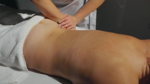 Jeune femme méconnaissable se faisant masser le dos. Massage du dos. La fille se fait masser le dos. procédures cosmétiques. — Video