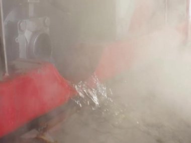 Endüstriyel suyun boşaltılması. Tankın kimyasal temizliğinden sonra atık su. Su borudan akıyor, sıcak su buharlaşıyor.