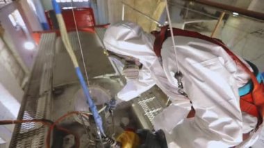 Tankerin otomatik buhar temizliği. Kimyasal koruma işçisi. Bir işçi içeriden buharlı bir tank kamyonunun kimyasal temizliğini yapar..