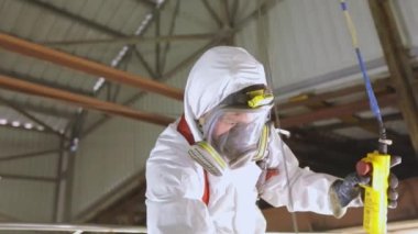 Kimyasal koruma işçisi. Temizlik istasyonunda koruyucu takım elbiseli bir işçi. İşçi zararlı kimyasallarla çalışır.