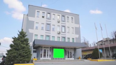 Yeşil ekranlı ofis binası. Reklam pankartı yeşil ekranda. Reklamlarınızı eklemek için yeşil ekranlı bir ofis binası..