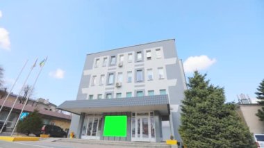 Yeşil ekranlı ofis binası. Reklam pankartı yeşil ekranda. Reklamlarınızı eklemek için yeşil ekranlı bir ofis binası..