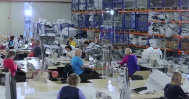 Büyük dikiş üretimi. Atölyede bir sürü terzi var. Giysi fabrikasının içi. Dikiş endüstrisindeki kadınlar