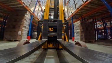 Forklift depodan geçiyor. Depoda özel araçlar dolaşıyor. Forklift POV. Bakış açısı