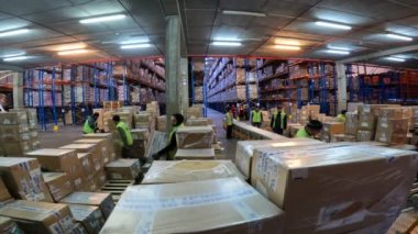 Mallar kamyondan boşaltılıyor. Malları kamyondan boşaltma işlemi. İşçiler kamyonu boşaltıyor. Modern depo