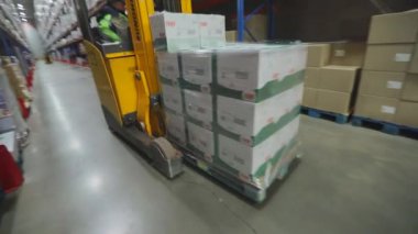 Modern bir forklift depodan geçiyor. Büyük, modern bir depo. Kargo modern bir forkliftle depodan taşınıyor.