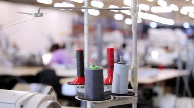 Dikiş fabrikasında dikiş malzemeleri. Dikiş fabrikasındaki dikiş işlemine yakın çekim. Bir tekstil fabrikasında ekipman.