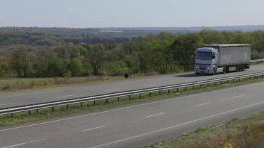 Kamyon güneşli havada otoyol boyunca sürer. Kamyon modern bir yolda gidiyor. Pistte kamyon var