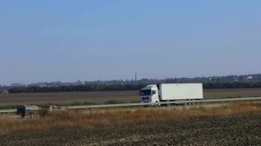Kamyon otoyolda gidiyor. Kamyon tarlaların etrafındaki otoyolda gidiyor.