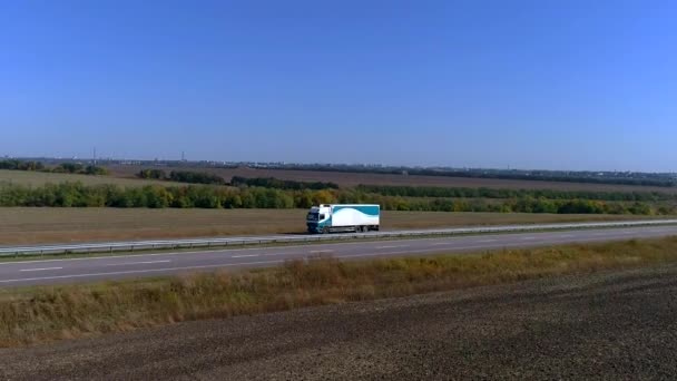 Ciężarówka jedzie autostradą. Ciężarówka jeździ po autostradzie wokół pól — Wideo stockowe