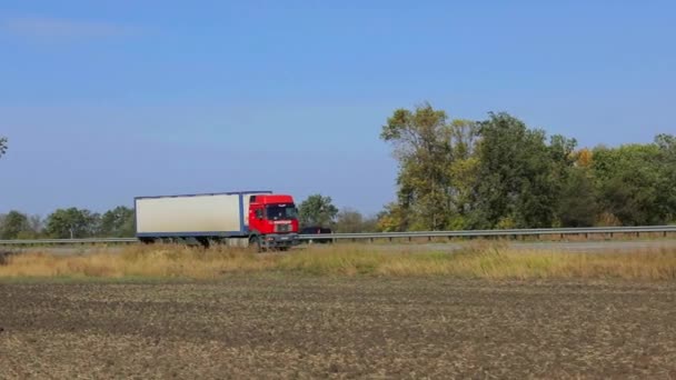 Biały wóz jedzie wzdłuż autostrady w słoneczną pogodę. Ciężarówka na autostradzie — Wideo stockowe