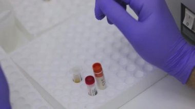 Laboratuvarda test tüpleriyle çalışıyorum. Laboratuvarda araştırma yapıyorum. Bilimadamı ayırıcıları yakın çekim ile karıştırdı.