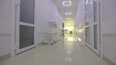 Kliniğin boş, parlak koridoru. Modern bir kliniğin içinde. Modern bir hastanenin koridorları. Kamera hastanenin boş koridoru boyunca dönüyor..