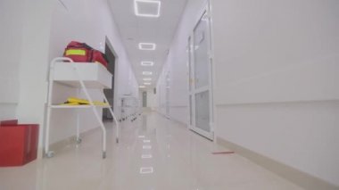 Modern bir kliniğin içinde. Kliniğin boş, parlak koridoru. Modern bir hastanenin koridorları. Kamera hastanenin boş koridoru boyunca dönüyor..