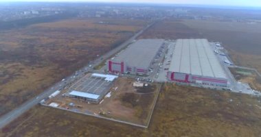 Modern endüstriyel bina havadan görüşü olan bir inşaat alanı. Büyük bir lojistik merkezinin inşaatı. Büyük, modern bir inşaat sahasının üzerinden uç.
