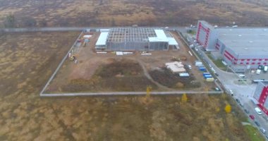 Modern endüstriyel bina havadan görüşü olan bir inşaat alanı. Büyük bir lojistik merkezinin inşaatı. Büyük, modern bir inşaat sahasının üzerinden uç.