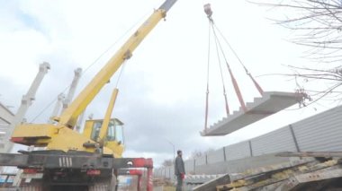 Bir vinç beton merdiveni kaldırır. Vinç beton levhayı kaldırır. İnşaat işi. Crane merdivenleri kaldırıyor.