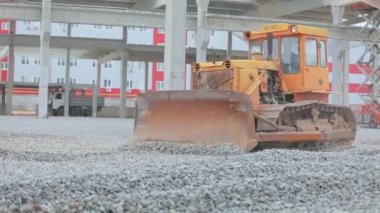 Buldozer toprak katmanını düzleştiriyor. Buldozer inşaat alanında çalışıyor. İnşaat alanında sarı buldozer. İnşaat alanında buldozer. Ağır inşaat ekipmanları