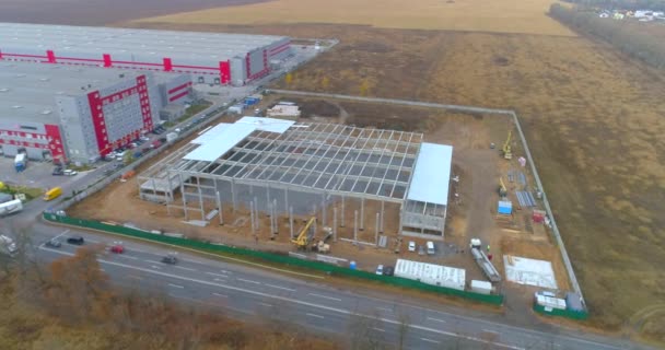 Construção de construção vista aérea. Construção de um grande armazém automatizado. Voo sobre um local de construção de armazém. — Vídeo de Stock