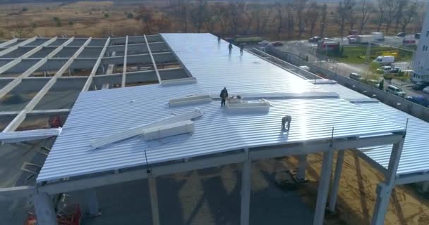 Industrieller Außenbereich. Bauarbeiter auf dem Dach des Gebäudes. Bau eines großen Industriegebäudes Luftaufnahme — Stockvideo