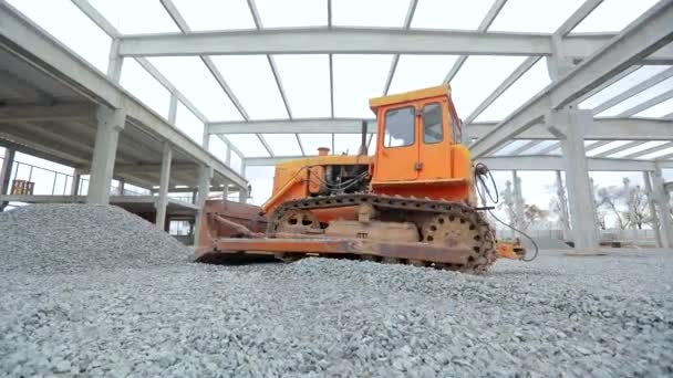 Gelbe Planierraupe arbeitet auf einer Baustelle. Die Planierraupe nivelliert die Bodenschicht. Gelbe Planierraupe auf der Baustelle. Bulldozer auf der Baustelle. Schwere Baumaschinen — Stockvideo