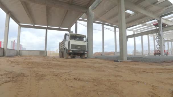 Το φορτηγό περνάει μέσα από την περιοχή του εργοταξίου. Φορτηγό στο εργοτάξιο. Μεταφορά φορτίου — Αρχείο Βίντεο