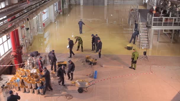 Zelfnivellerende vloer in de werkplaats. Bouwvakkers maken een zelfnivellerende vloer in de werkplaats. Zelfnivellerende vloer over een groot gebied. — Stockvideo