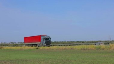 Kamyon güneşli havada otoyol boyunca sürer. Kamyon modern bir yolda gidiyor. Pistte kamyon var