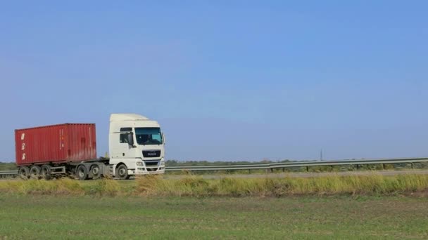 Вантажні перевезення. Вантажівка їде по сучасній дорозі. Вантажівка їде по шосе в сонячну погоду. Вантажівка на колії — стокове відео