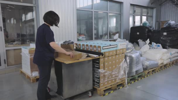 Οι εργαζόμενοι συσκευάζουν έτοιμα προϊόντα σε ένα κουτί. Συσκευασία των τελικών προϊόντων σε κουτί. — Αρχείο Βίντεο